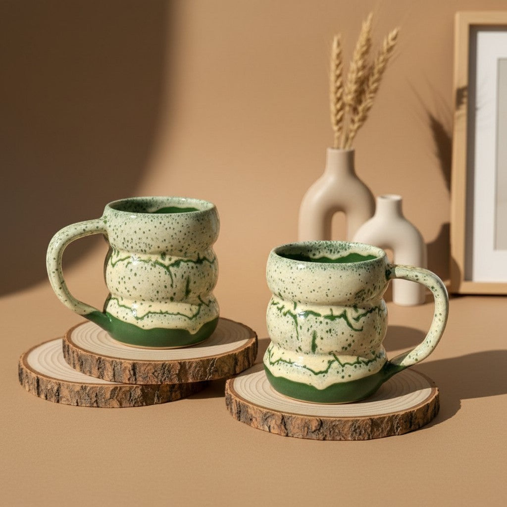 Two textured green marble triple bubble mugs with handles resting on wooden coasters, rustic design. Eternal Pottery.
