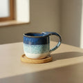 Eternal Pottery textured ocean mermaid mug with handle on a wooden coaster.