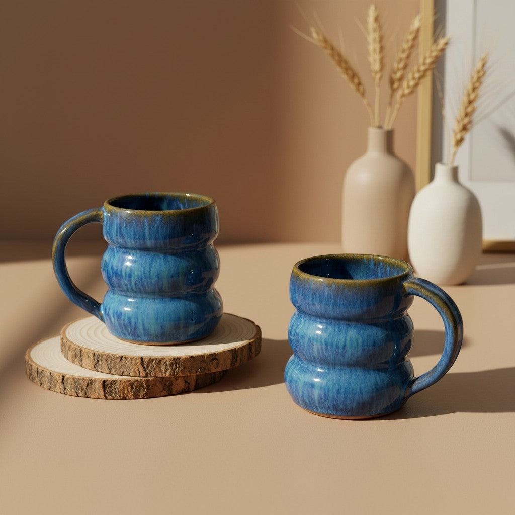 Two textured ocean triple bubble mugs with handles resting on wooden coasters, rustic design. Eternal Pottery.