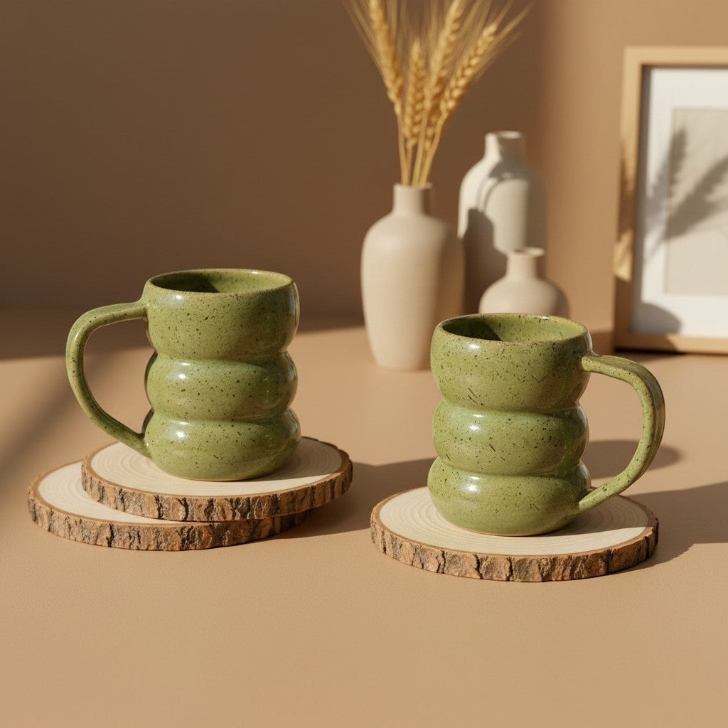 Two textured olive core triple bubble mugs with handles resting on wooden coasters, rustic design. Eternal Pottery.
